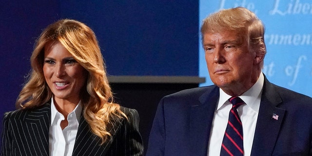In this September 29, 2020 file photo, President Donald Trump and First Lady Melania Trump hold hands on stage after the first presidential debate at Case Western University and the Cleveland Clinic in Cleveland, Ohio.  (AP Photo / Julio Cortez, file)
