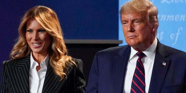 In this Sept. 29, 2020, file photo, President Donald Trump and first lady Melania Trump hold hands on stage after the first presidential debate at Case Western University and Cleveland Clinic, in Cleveland, Ohio.