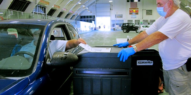 A voter casts a ballot at a drive-thru voting station in the Barre Civic Center in Vermont's statewide primary in Barre, Vt.  (AP Photo/Lisa Rathke, File)