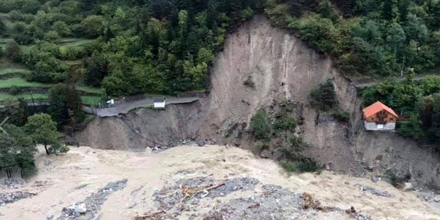 This aerial view provided Sunday, Oct. 4, 2020, by the Alpes Maritimes region fire brigade show a house keeping a fragile balance on a hill while a river floods Saturday, Oct. 3, 2020, near La Vesubie, southern France.