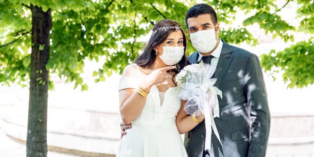 Couples around the globe are adjusting their wedding plans due to the coronavirus pandemic, according to The Knot Worldwide. (iStock)