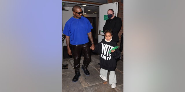 Kanye West with daughter North West in London, England. North, 7, rocks the rapper's 'Vote Kanye' merch.