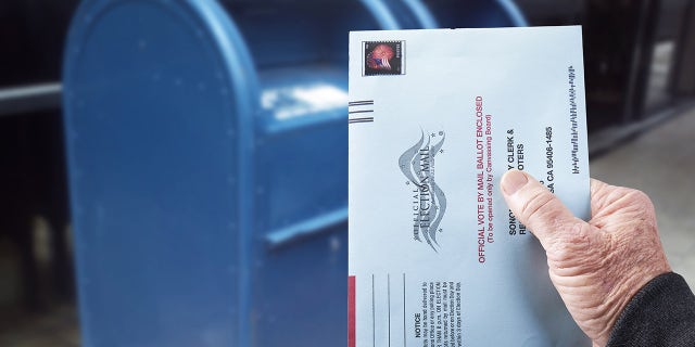Person mailing absentee ballot for voting in an election by mail in Gualala, Calif., July 4, 2020.
