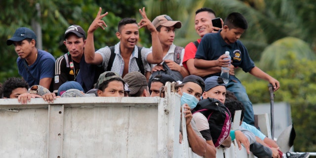 Migrants get a free ride from a trucker toward the Guatemalan border after leaving San Pedro Sula, Honduras. (AP)