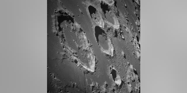 This photograph was taken from the Apollo 8 spacecraft with a long focal length lens, looking south at the large Goclenius crater, which is in the foreground. (NASA / JSC)