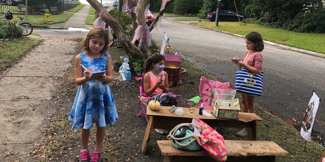 Maya Gebler, center, Cate and Sophie Carroll , right, write letters to fairies in Norfolk, Virginia on Monday Oct. 12, 2020.