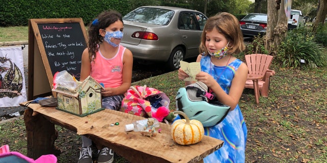 Maya Gebler and Cate Carroll read letters they've received from fairies in Norfolk, Va., on Monday Oct. 12, 2020.
