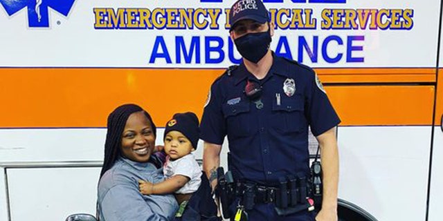 Metro Nashville Police Officer Philip Claibourne poses for a photo with Tanisha Rutledge, 29, and her 9-month-old baby boy.