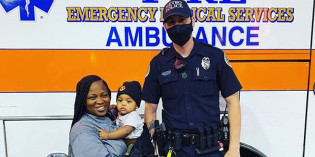 Metro Nashville Police Officer Philip Claibourne poses for a photo with Tanisha Rutledge, 29, and her 9-month-old baby boy.