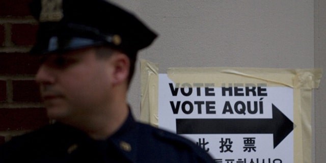 A New York City police officer stands guard outside a polling station in a public school Nov. 2, 2010 in New York.  (DON EMMERT/AFP via Getty Images)