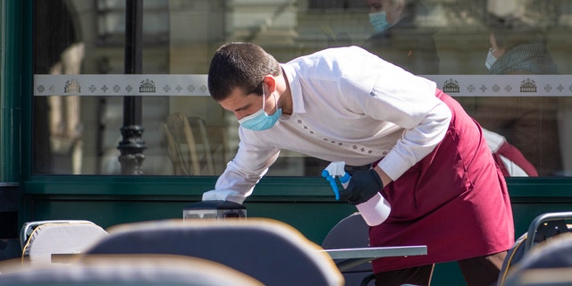 Waiter cleaning outdoor table (iStock)