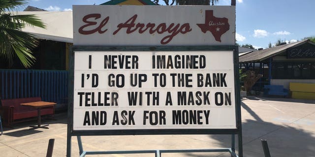 "I never imagined I'd go to the bank teller with a mask on and ask for money,” one sign teased.
