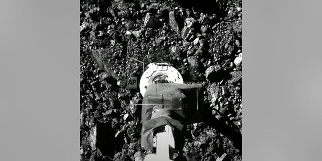 Dans cette image tirée d'une vidéo publiée par la NASA, le vaisseau spatial Osiris-Rex touche la surface de l'astéroïde Bennu le mardi 20 octobre 2020 (NASA via AP)