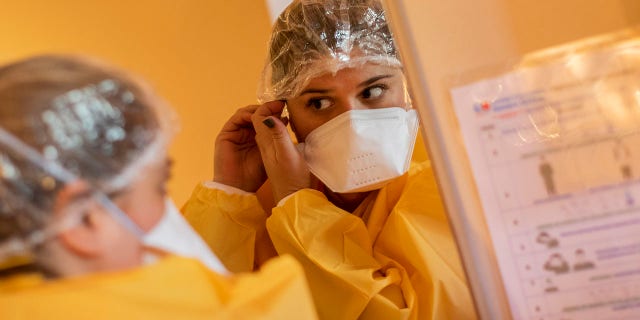 Nurse Paula Gonzalez dresses in full protective gear before entering the red zone of a hotel for COVID-19 patients under quarantine in Leganes, outskirts of Madrid, Spain, Thursday, Oct. 15, 2020. The red zone marks the hotel area where coronavirus patients stay. (AP Photo/Bernat Armangue)
