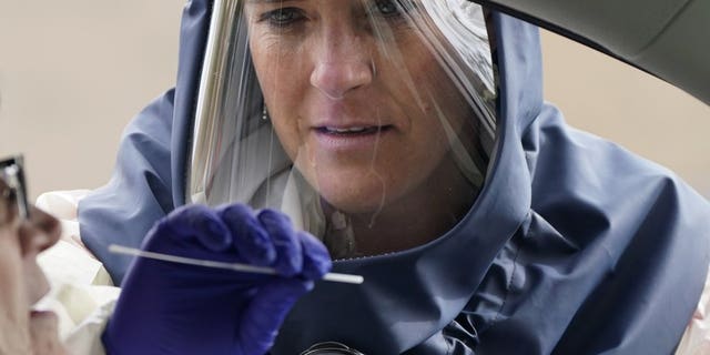 Salt Lake County Health Department public health nurse Lee Cherie Booth performs a coronavirus test on Friday in Salt Lake City. (AP Photo/Rick Bowmer,