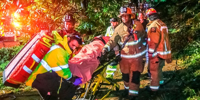 Atlanta firefighters transport a man they freed who was trapped in his third-floor bedroom after a tree came crashing down on a home on Brookview Drive in Atlanta, as Tropical Storm Zeta sped across the Southeast Thursday, Oct. 29, 2020.