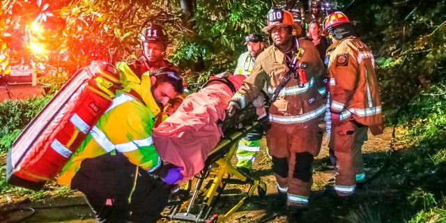 Atlanta firefighters transport a man they freed who was trapped in his third-floor bedroom after a tree came crashing down on a home on Brookview Drive in Atlanta, as Tropical Storm Zeta sped across the Southeast Thursday, Oct. 29, 2020.