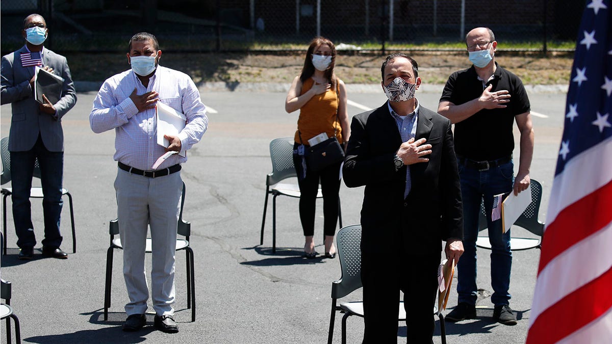 <br>
New U.S. citizens, socially distanced, recite the Pledge of Allegiance outside the U.S. Citizenship and Immigration Services building in Lawrence, Mass., June 4, 2020. (Associated Press)
