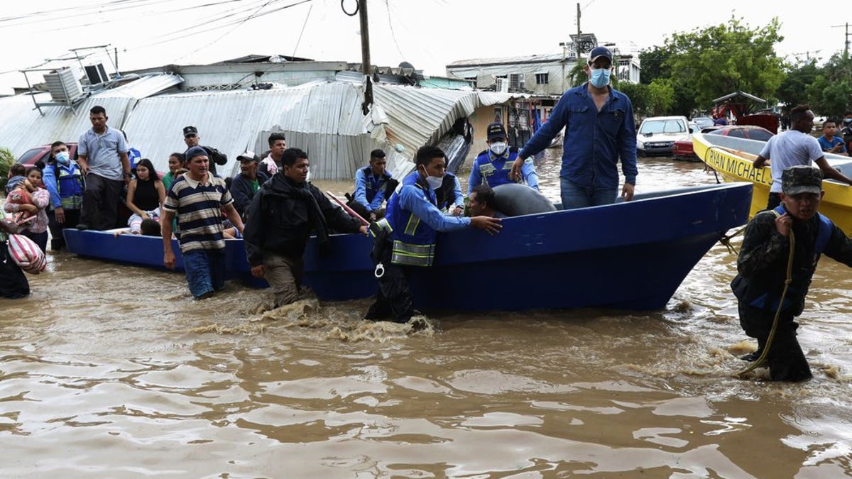 Police help residents move to higher ground after they were rescued from a flooded area, in Planeta, Honduras, Nov. 6. As the remnants of Hurricane Eta moved back over Caribbean waters, governments in Central America worked to tally the displaced and dead, and recover bodies from landslides and flooding that claimed dozens of lives from Guatemala to Panama. (AP Photo/Delmer Martinez)