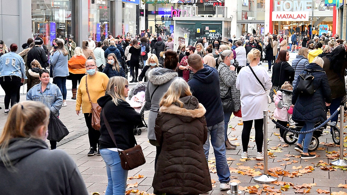 Shoppers in Cardiff, Wales, Monday Nov. 9, 2020, after restrictions imposed by the Welsh government are relaxed following a two-week lockdown across Wales. (Ben Birchall/PA via AP)