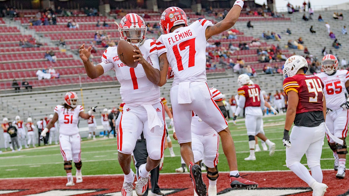 Louisiana-Lafayette quarterback Levi Lewis (1) celebrates a touchdown with wide receiver Dontae Fleming (17) during the first half of an NCAA college football game against Louisiana-Monroe in Monroe, La., Saturday, Nov. 28, 2020. (AP Photo/Matthew Hinton)