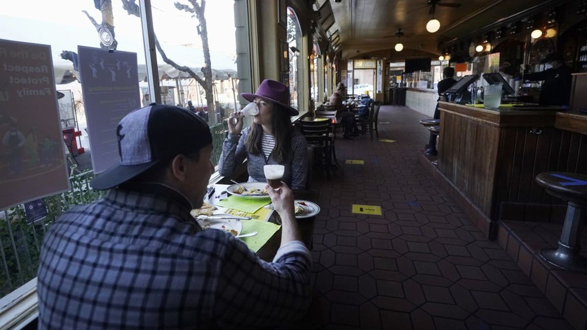 In this Nov. 12 photo, a couple eat inside at the Buena Vista Cafe during the coronavirus outbreak in San Francisco. With the coronavirus coming back with a vengeance across the country and the U.S. facing a long, dark winter, governors and other elected officials are showing little appetite for reimposing the kind of lockdowns and large-scale business closings seen last spring. (AP Photo/Jeff Chiu, File)