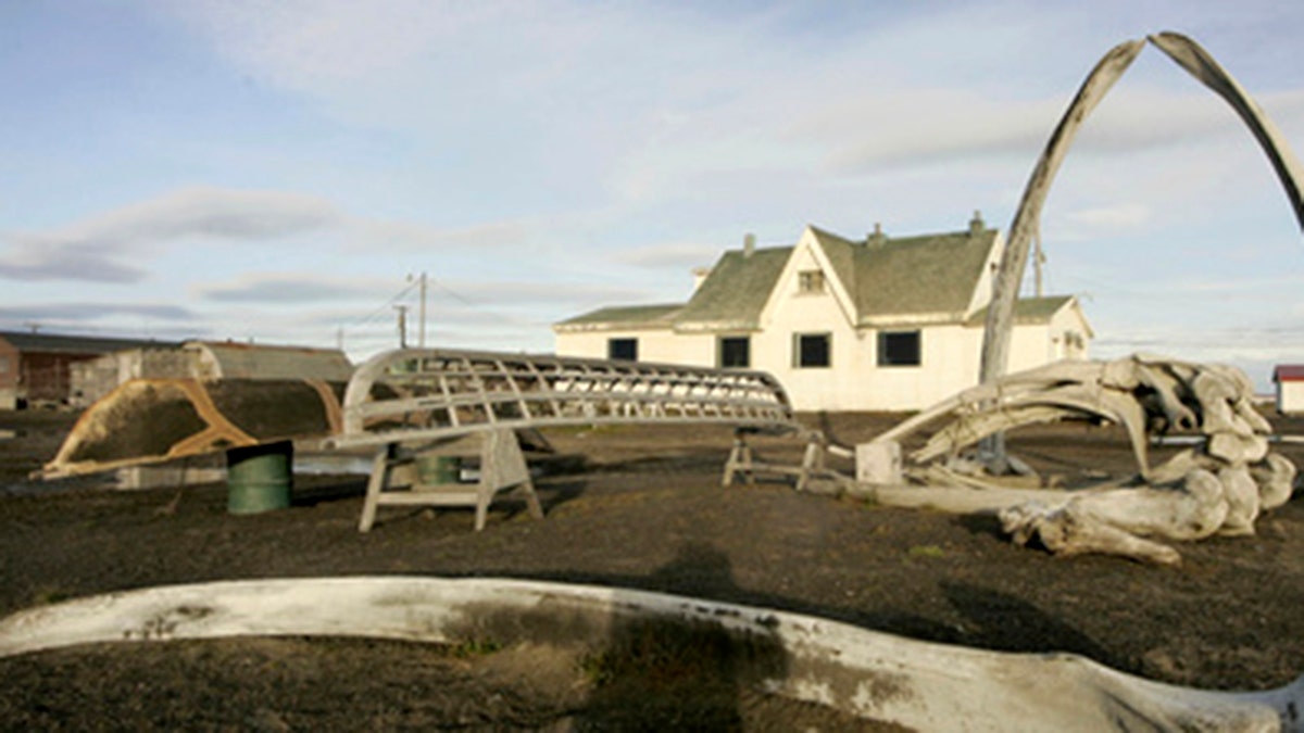 In this Aug. 12, 2005, file photo, a skin boat display sits next to whale bones and an arch made of a whale jaw on the beach at Brower's Cafe in Barrow, Alaska.