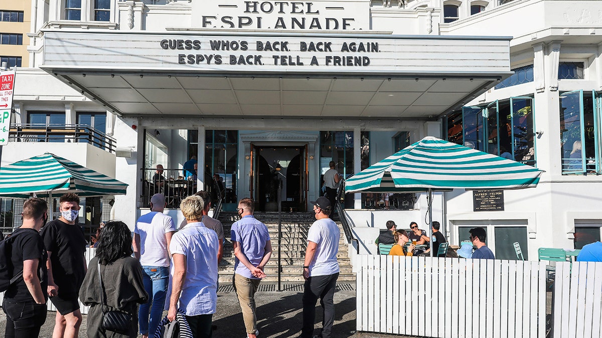 People line up outside a popular pub and restaurant in St Kilda in Melbourne, Australia, Wednesday, Oct. 28, 2020. Melbourne, Australia's former coronavirus hotspot, emerged from a lockdown at midnight Tuesday, restaurants, cafes and bars were allowed to open and outdoor contact sports can resume. (AP Photo/Asanka Brendon Ratnayake)