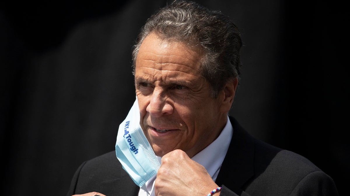 In this June 15, 2020, file photo, New York Gov. Andrew Cuomo removes a mask as he holds a news conference in Tarrytown, N.Y. On Wednesday, Cuomo announced new coronavirus restrictions that take effect Friday. (AP Photo/Mark Lennihan, File)