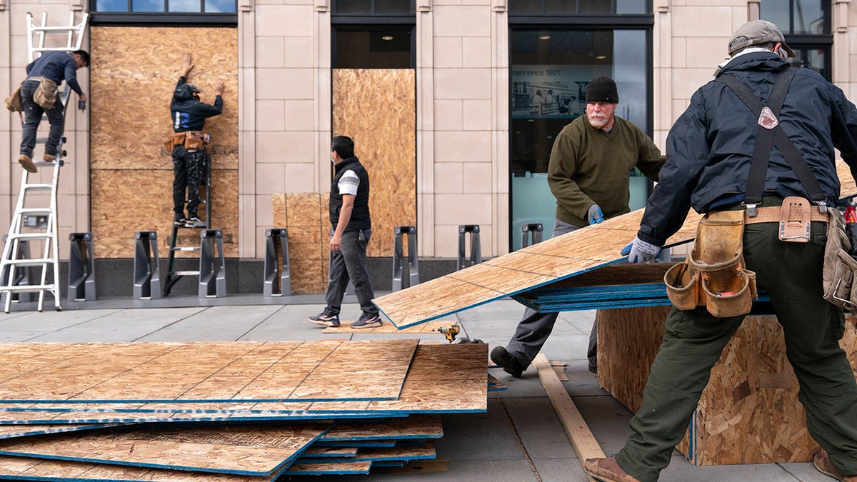 Ahead of the presidential election, workers with Baguer Construction LLC board up a Walgreens on U Street NW, Friday, Oct. 30, 2020, in Washington. The site manager said they had been hired to put protective coverings on several Walgreens throughout the city. (AP Photo/Jacquelyn Martin)