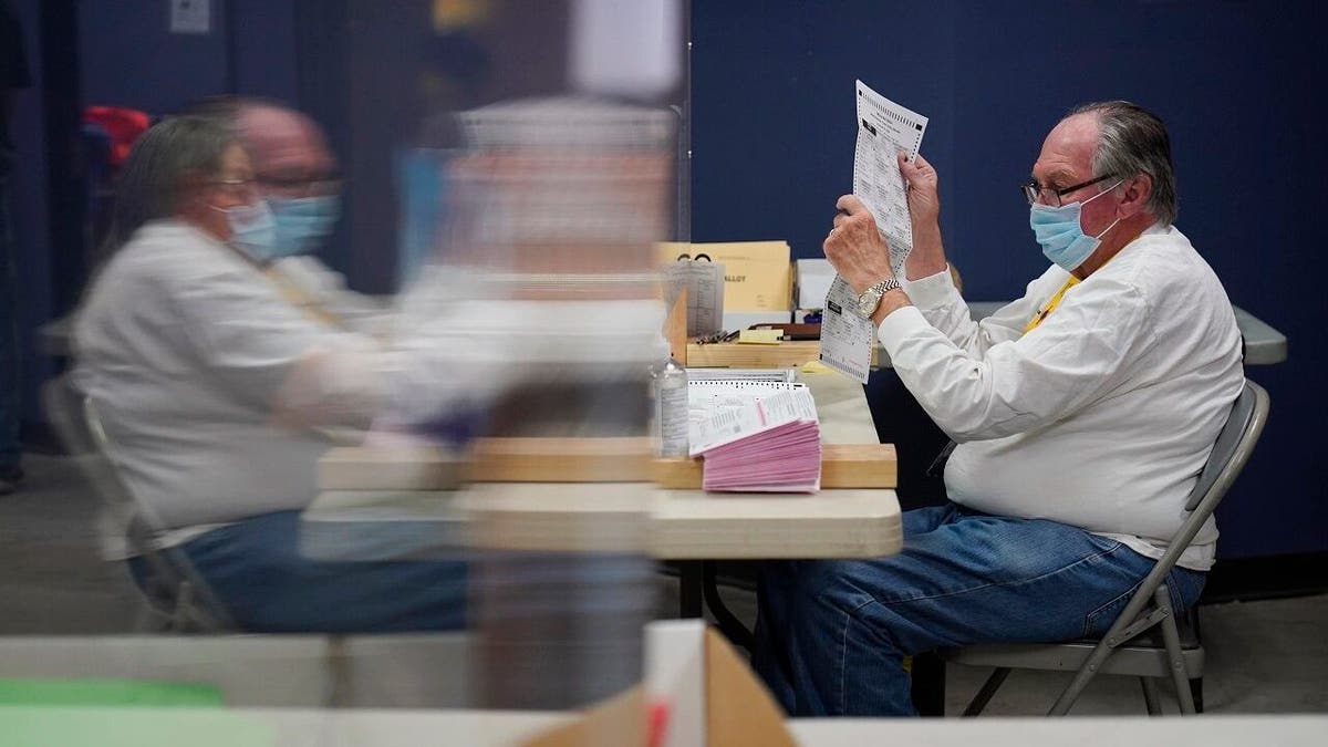 County employees process mail-in ballots at a Clark County election department facility Saturday, Oct. 31, 2020, in Las Vegas. (AP Photo/John Locher)