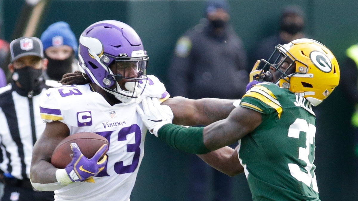 Minnesota Vikings' Dalvin Cook tries to get padt Green Bay Packers' Josh Jackson during the second half of an NFL football game Sunday, Nov. 1, 2020, in Green Bay, Wis. (AP Photo/Mike Roemer)