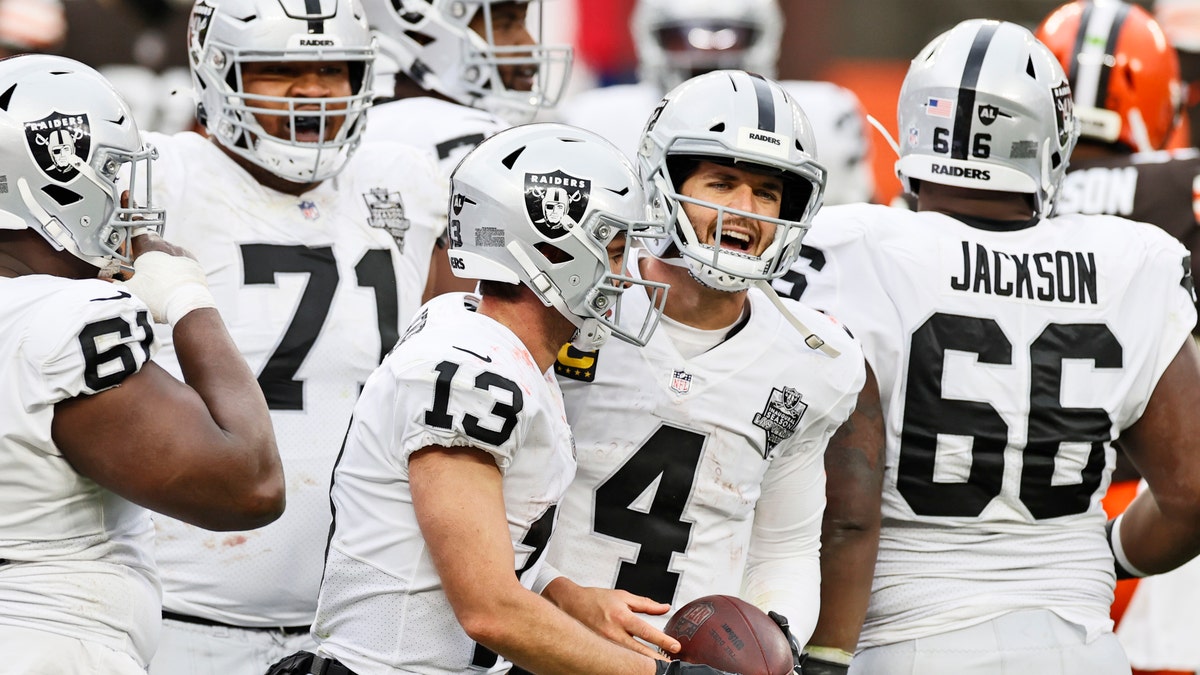 Las Vegas Raiders quarterback Derek Carr (4) and wide receiver Hunter Renfrow (13) celebrate after Renfrow scored a 4-yard touchdown during the second half of an NFL football game against the Cleveland Browns, Sunday, Nov. 1, 2020, in Cleveland. (AP Photo/Ron Schwane)