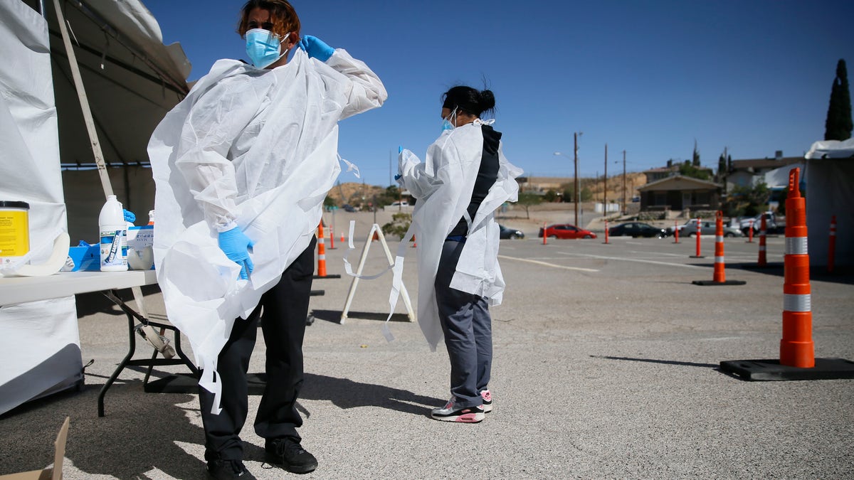 Jacob Newberry puts on new PPE at the COVID-19 state drive-thru testing location at UTEP in El Paso, Texas on Oct. 26, 2020.  (Briana Sanchez/The El Paso Times via AP, File)