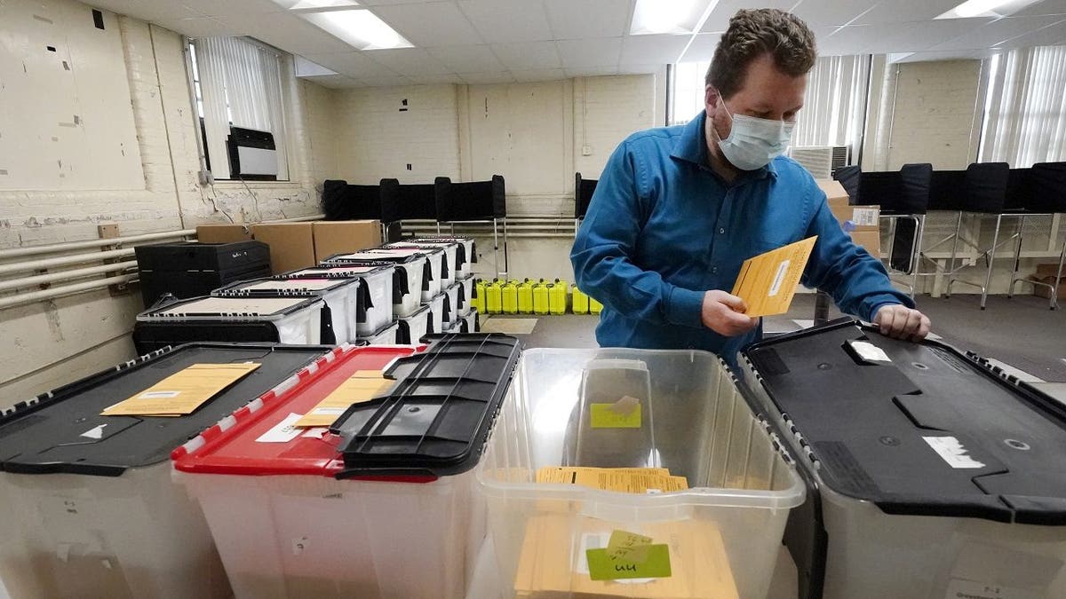 Assistant City Clerk James Blatchford prepares absentee and early vote ballots at Haverhill City Hall to be sent to precincts for Election Day counting, Monday, Nov. 2, 2020, in Haverhill, Mass. (AP Photo/Elise Amendola)