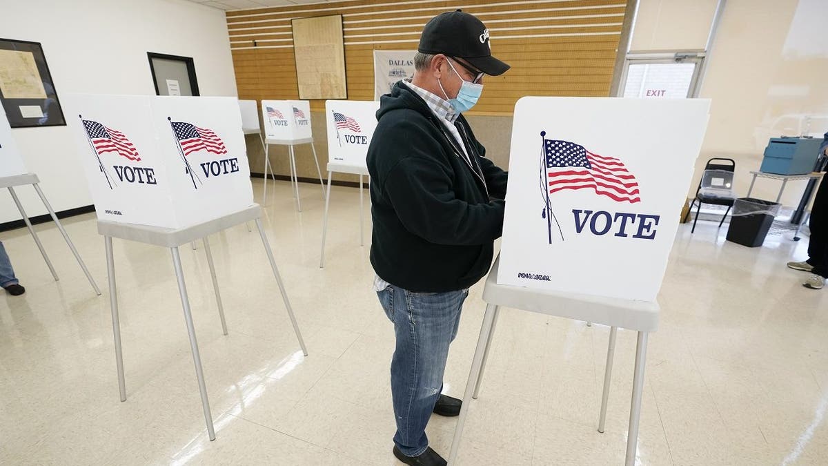 FILE - In this Oct. 20, 2020 file photo, Kelly Wingfield, of Urbandale, Iowa, fills out his ballot during early voting in the general election, in Adel, Iowa. (AP Photo/Charlie Neibergall, File)