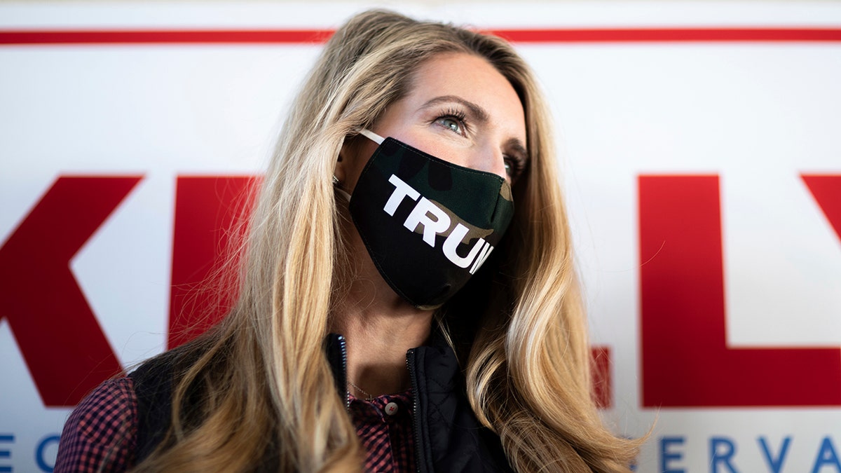Sen. Kelly Loeffler, R-Ga., who is running for reelection, wears a Trump mask as she speaks to the media at Cobb County International Airport on Election Day, Tuesday, Nov. 3, 2020, in Kennesaw, Ga. (AP Photo/Branden Camp)