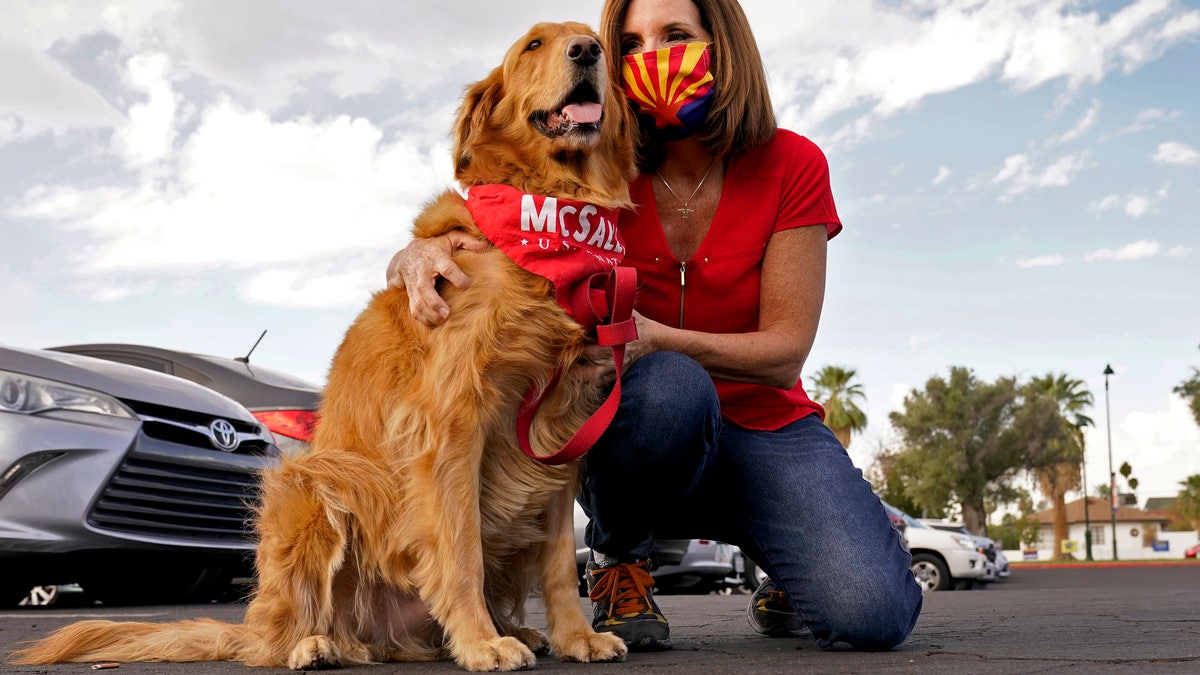 U.S. Sen. Martha McSally, R-Ariz., hugs her dog Boomer prior to greeting voters at a polling station, Tuesday, Nov. 3, 2020, in Mesa, Ariz. (AP Photo/Matt York)