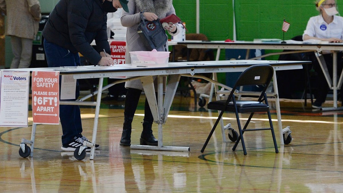 Voters casting their ballot at Frederick Douglass Academy in Detroit on Tuesday. Nearly 19,000 people registered and voted on the same day across the state Tuesday, officials said. (Clarence Tabb, Jr./Detroit News via AP)