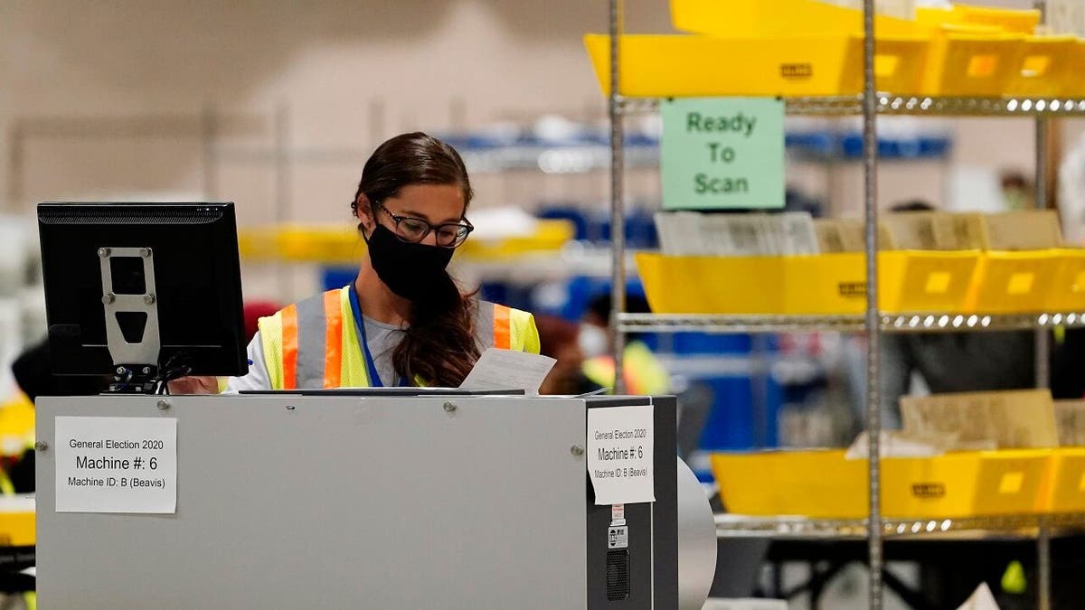 A Philadelphia election worker scans ballots for the 2020 general election in the United States at the Pennsylvania Convention Center, Tuesday, Nov. 3, 2020, in Philadelphia. (AP Photo/Matt Slocum)