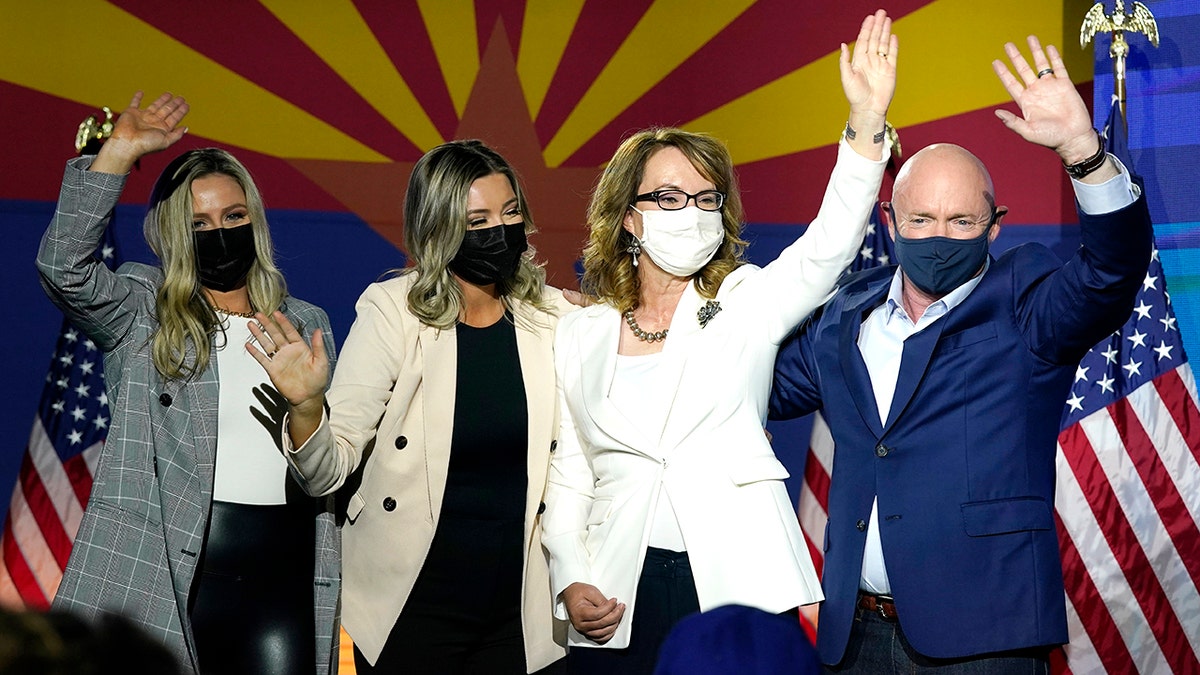 Sen. Mark Kelly, D-Ariz., waves to supporters along with his wife Gabrielle Giffords, second from right, and daughters, Claire Kelly, left, and Claudia Kelly, second from left, during an election night event Tuesday, Nov. 3, 2020 in Tucson, Ariz. Kelly is up for reelection in 2022. (AP Photo/Ross D. Franklin)