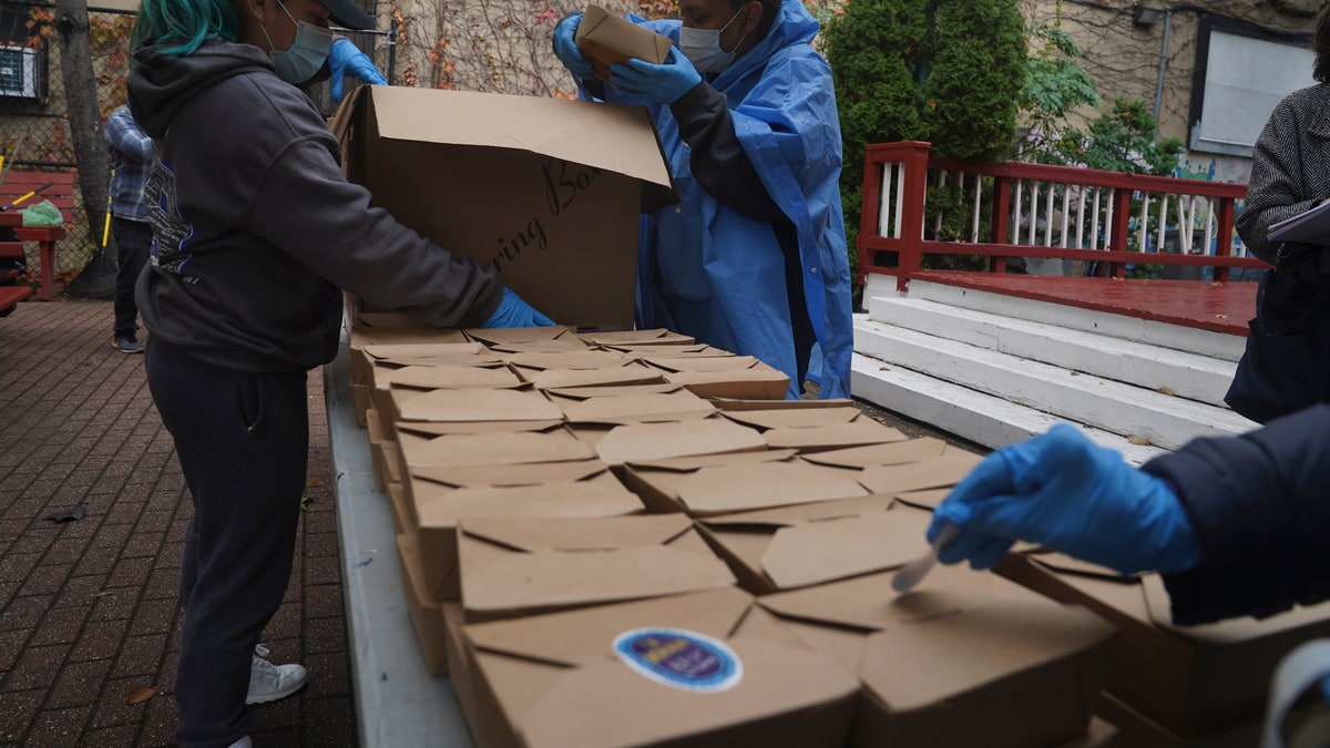 Volunteers unload boxed meals prepared at La Morada, on Wednesday, Oct. 28, 2020, in New York. (AP Photo/Bebeto Matthews)