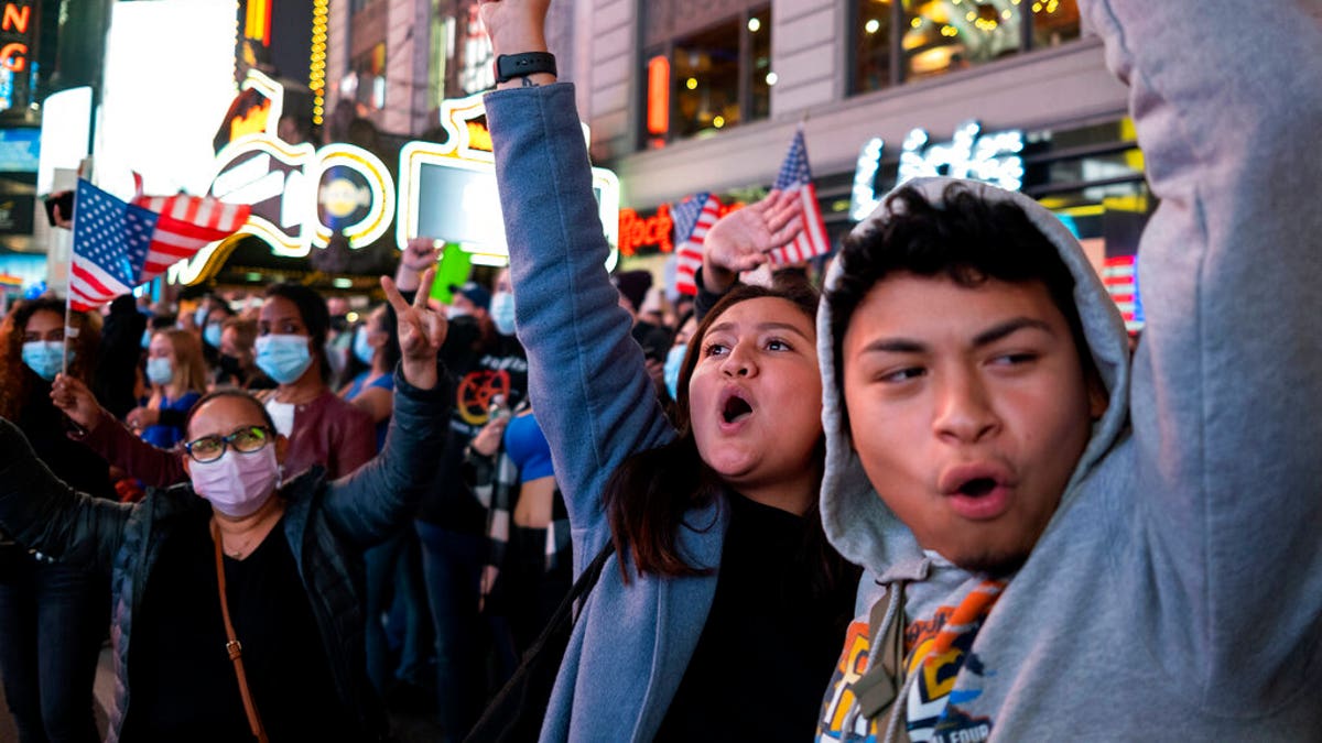 People celebrate in Times Square after former Vice President Joe Biden was announced as the winner over President Donald Trump to become the 46th president of the United States.