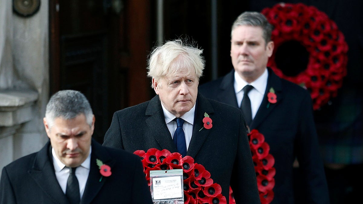Britian's Prime Minister Boris Johnson carries a wreath, during the Remembrance Sunday service at the Cenotaph, in Whitehall, London, Sunday, Nov. 8, 2020.