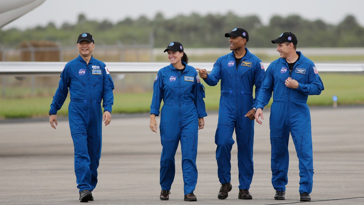 Astronaut Soichi Noguchi, of Japan, from left, NASA Astronauts Shannon Walker, Victor Glover and Michael Hopkins walk after arriving at Kennedy Space Center, Sunday, Nov. 8, 2020, in Cape Canaveral, Fla. The four astronauts will fly on the SpaceX Crew-1 mission to the International Space Station scheduled for launch on Nov. 14, 2020 (AP Photo/Terry Renna)