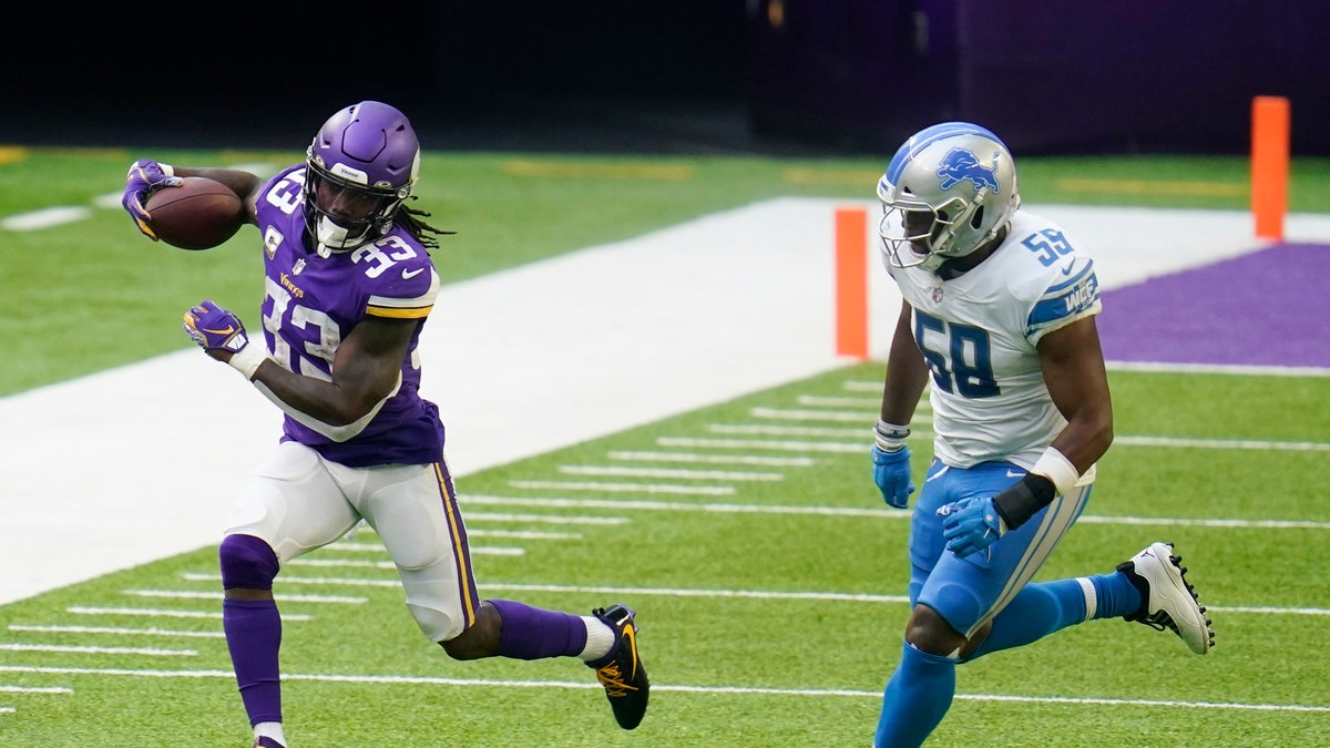 Minnesota Vikings running back Dalvin Cook (33) runs from Detroit Lions linebacker Reggie Ragland, right, during the second half of an NFL football game, Sunday, Nov. 8, 2020, in Minneapolis. (AP Photo/Jim Mone)