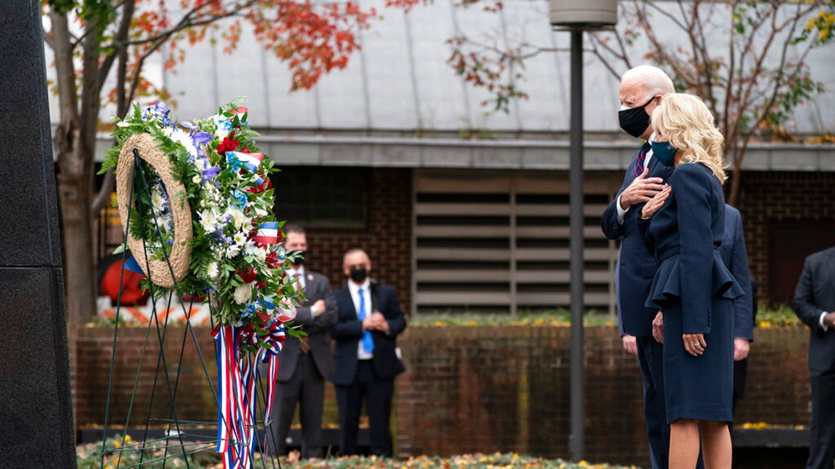 President-elect Joe Biden, and Jill Biden, stand with their hands over their hearts after placing a wreath at the Philadelphia Korean War Memorial at Penn's Landing, on Veterans Day, Wednesday, Nov. 11, 2020, in Philadelphia. (AP Photo/Alex Brandon)