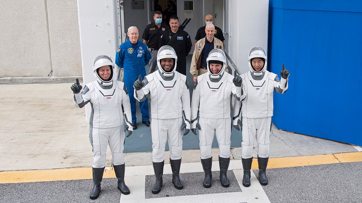 NASA astronauts, from left, Shannon Walker, Victor Glover, Mike Hopkins and Japan Aerospace Exploration Agency (JAXA) astronaut Soichi Noguchi, right, wearing SpaceX spacesuits, stop to pose for a picture as walk out of the Neil A. Armstrong Operations and Checkout Building to depart for Launch Complex 39A during a dress rehearsal Thursday, Nov. 12, 2020, at NASA's Kennedy Space Center in Cape Canaveral, Fla.