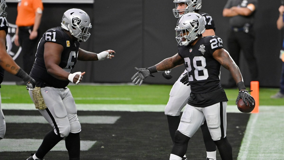Las Vegas Raiders center Rodney Hudson (61) celebrates after running back Josh Jacobs (28) scored a touchdown against the Denver Broncos during the first half of an NFL football game, Sunday, Nov. 15, 2020, in Las Vegas. (AP Photo/David Becker)
