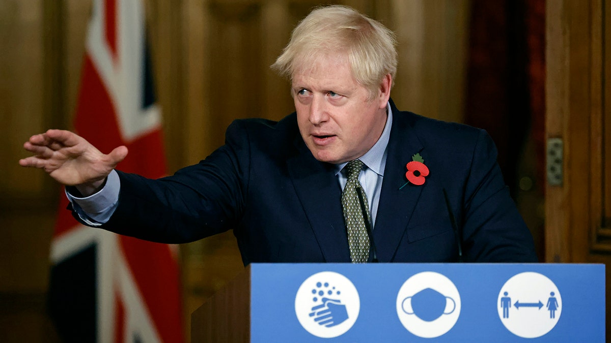 FILE - In this Nov. 9, 2020 file photo Britain's Prime Minister Boris Johnson reaches out during a virtual press conference on the coronavirus pandemic at 10 Downing Street in central London. Johnson is self-isolating after being told he came into contact with someone who tested positive for the coronavirus, officials said Sunday Nov. 15. "He will carry on working from Downing Street, including on leading the government's response to the coronavirus pandemic," a statement from his office said. (Tolga Akmen / Pool via AP, File)